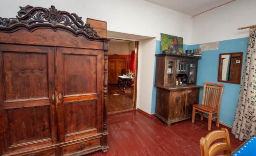 a room with a large wooden wardrobe and a chair at Baltā māja in Pilsrundāle