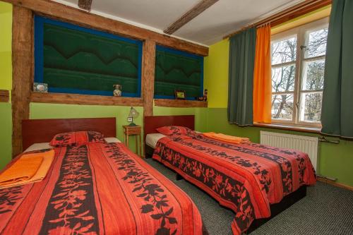 two beds in a room with green walls at Baltā māja in Pilsrundāle