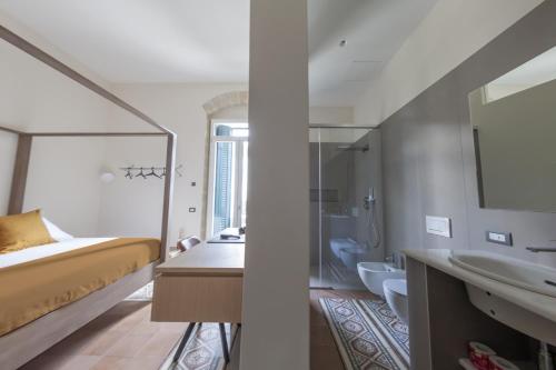 a bedroom with a bed and a sink and a mirror at METEORON Luxury Rooms in Matera
