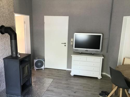 a living room with a television and a stove at Apartment am Park -Calluna in Schneverdingen