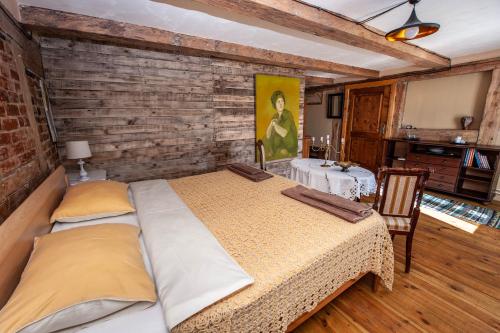 a bedroom with a large bed and a table at Baltā māja in Pilsrundāle