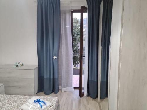 a bedroom with blue curtains and a window at B&B Villa Chiara - Bed And Breakfast in Taormina