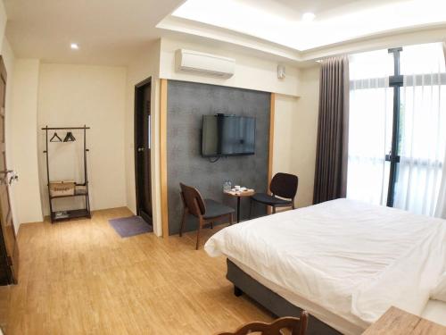 ZhuqiにあるAlishan Zhuqi Homestay #57のベッドとテーブルとテレビがあるホテルの部屋