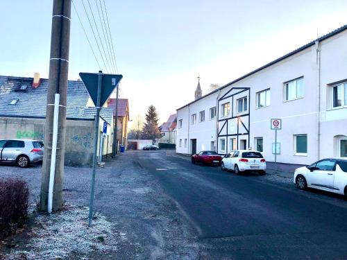 une rue avec des voitures garées sur le bord de la route dans l'établissement #WORLD Monteurzimmer, à Schkeuditz