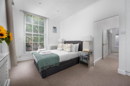 - une chambre blanche avec un lit et une fenêtre dans l'établissement Anderson Street by CAPITAL, à Londres