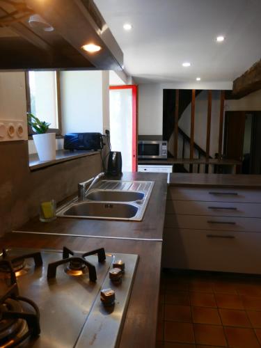 a kitchen with a sink and a counter top at Maison familiale, 15couchages, de charme au cœur de la Bretagne - 20 min de Vannes in Lizio