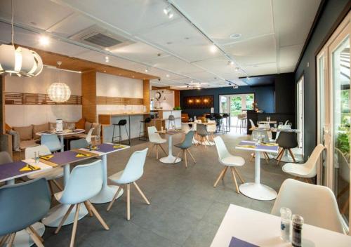 a restaurant with tables and chairs and a cafeteria at Campanile Hotel & Restaurant Liège / Luik in Liège