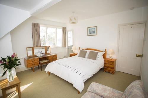 a bedroom with a bed and a desk and a window at Sunnycroft in Deal