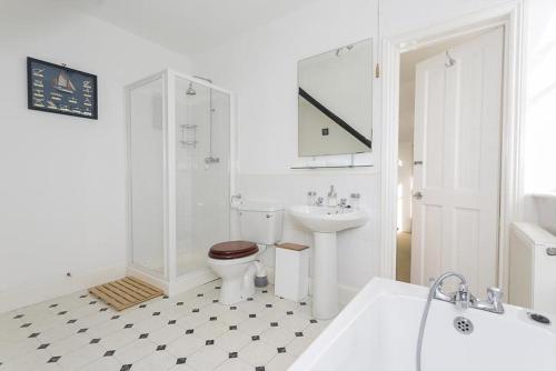 a white bathroom with a toilet and a sink at Sunnycroft in Deal