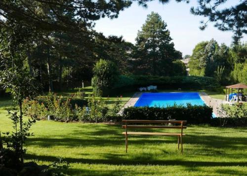 a bench sitting in the grass next to a swimming pool at Casa MariaLuisa in San Lorenzo Nuovo