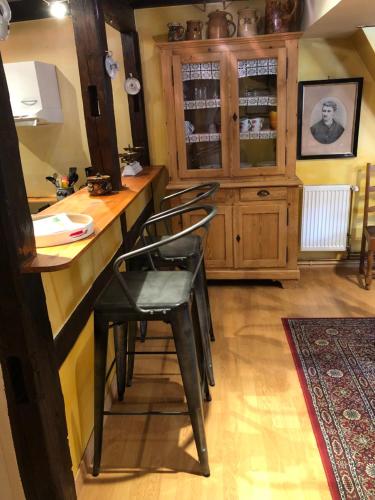 a kitchen with a counter with stools at a bar at Les Gîtes Coeur de Vigne in Riquewihr