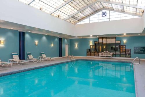 a pool in a hotel with chairs and a room at La Quinta by Wyndham Secaucus Meadowlands in Secaucus