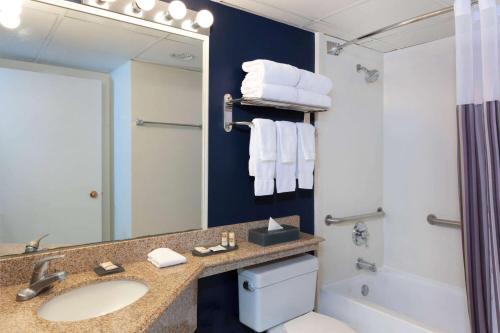 a bathroom with a sink and a toilet and a mirror at La Quinta by Wyndham Secaucus Meadowlands in Secaucus