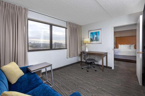 a hotel room with a couch and a desk and a bed at La Quinta by Wyndham Secaucus Meadowlands in Secaucus