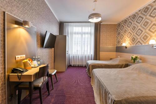 pokój hotelowy z dwoma łóżkami i biurkiem w obiekcie Hotel Kazimierz w Krakowie