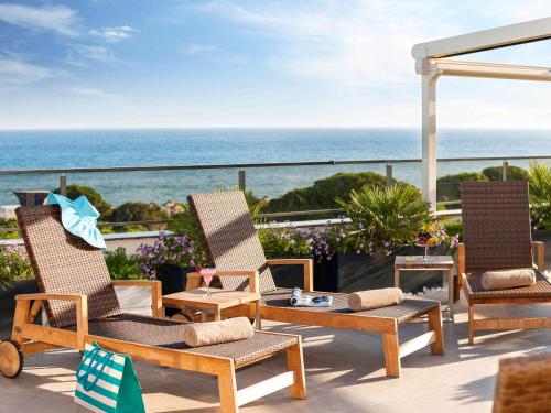 a patio with chairs and a table and the ocean at Rixos Premium Belek - The Land of Legends Access in Belek