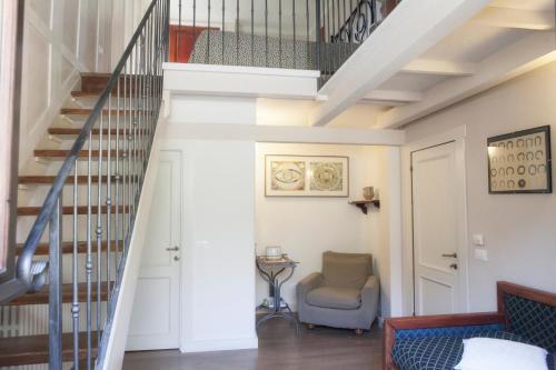 a staircase in a living room with a couch and a chair at Malvarina in Capodacqua