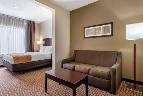Habitación de hotel con cama y sofá en Comfort Suites en Marion