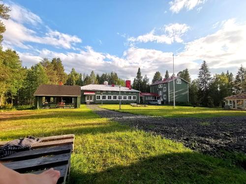 a person sitting on a bench in front of a building at Taigaschool Eco Hotel in Virrankylä