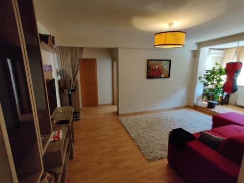 sala de estar con sofá rojo y TV en Lucky Home Timisoara 1 en Timişoara