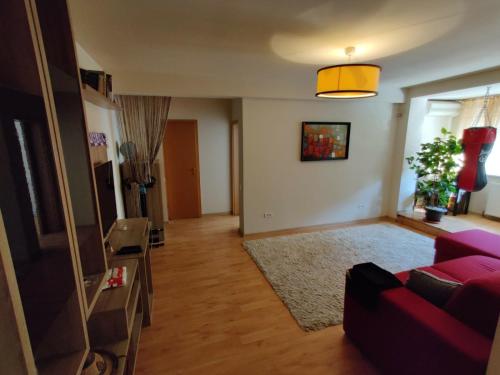 a living room with a red couch and a television at Lucky Home Timisoara 1 in Timişoara