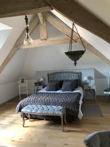 Schlafzimmer mit einem Bett mit einer Bank in der Unterkunft Au gré des saisons in Héricourt