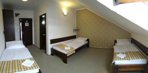 Cette chambre dispose de 3 lits et d'un escalier. dans l'établissement Restaurant and Pension Stenly, à Spišský Štvrtok