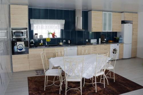 a kitchen with a table and chairs in a room at Casinha das Bonecas - Casa com Piscina Privada in Aveiro