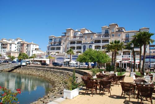 un grupo de mesas y sillas junto a un río con edificios en Marina III by Ĥ, en Isla del Moral