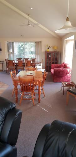 a living room filled with furniture and a table at Shearwater Cottages in Port Sorell