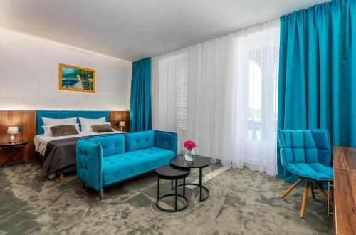 a hotel room with a blue bed and blue chairs at Brijuni Hotel Neptun in Fažana