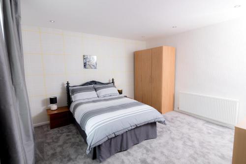 a bedroom with a bed and a wooden cabinet at Entire House - 2 Bedroom - 3 Bed - Free wifi - TV in Clayton le Moors