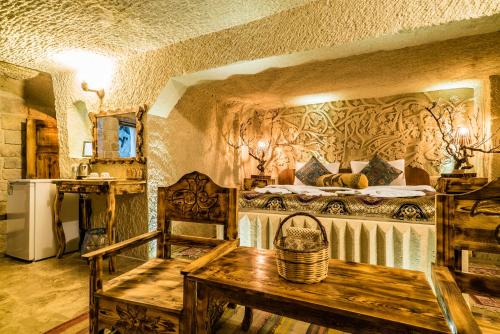1 dormitorio con 1 cama y 1 mesa en una habitación en Cappadocia Ennar Cave Swimming Pool Hot & SPA, en Nevşehir