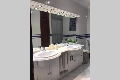 a bathroom with two sinks and a large mirror at Faro Appartment with unique terrace in Faro