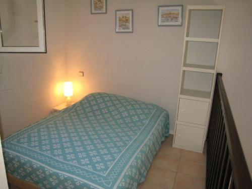 - une petite chambre avec un lit et une étagère dans l'établissement Duplex, vue panoramique sur la Méditerranée, piscine, garage, à Saint-Raphaël