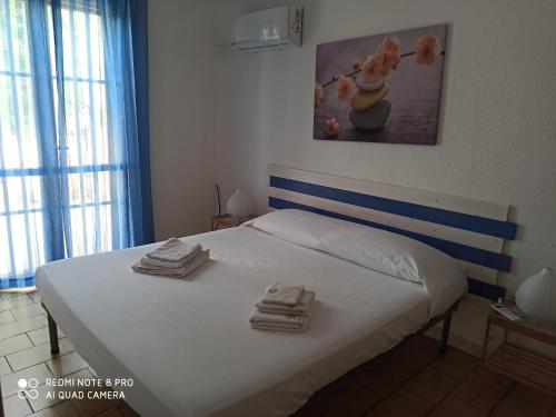 クアルトゥ・サンテーレナにあるL'olmo sul mare IUN P1250のベッドルーム1室(白いベッド1台、タオル付)