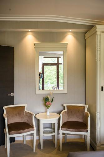two chairs and a table in a room with a window at HOTEL CARPAT INN in Azuga