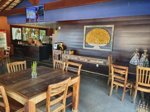 a dining room with a wooden table and chairs at Bangalô Villas do Pratagy in Maceió