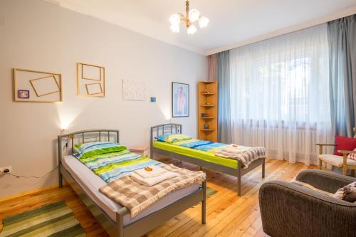 a bedroom with two beds and a couch at PhotoHome - Aristocratic Center of Sofia in Sofia