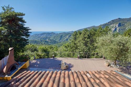 a house with a roof with mountains in the background at Rivierarent Villa Pina in Magliolo
