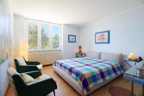 a bedroom with a bed and a couch and a chair at Rivierarent Villa Pina in Magliolo