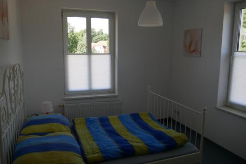 1 dormitorio pequeño con 1 cama y 2 ventanas en Großzügige Wohnung in Mecklenburg zwischen Wald und Seen, en Krakow am See