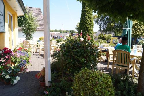 a man sitting at a table in a garden at Hotel Neuses in Cuxhaven