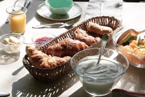 a table with two baskets of pastries and a glass of milk at Grange Bleuet in Aubeterre-sur-Dronne