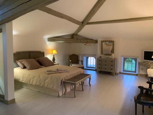 a bedroom with a large bed and a table at Domaine de la Hure in Saint-Symphorien