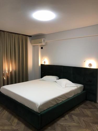 a bedroom with a large bed with white sheets at Hotel Lido in Durrës