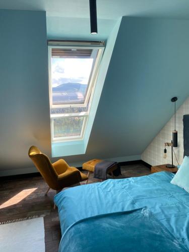 1 dormitorio con 1 cama, 1 silla y 1 ventana en Apartament No.813, en Szklarska Poręba