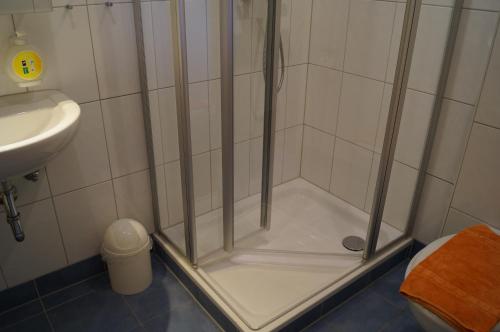 a shower with a glass door in a bathroom at Hotel Neuses in Cuxhaven