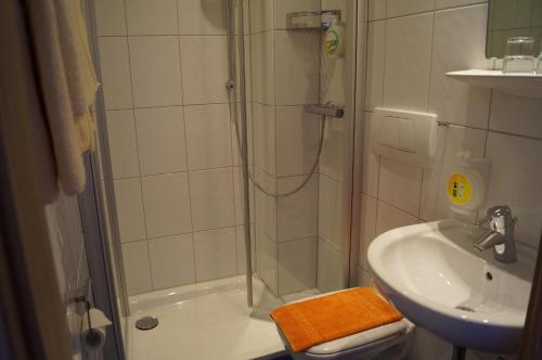 a bathroom with a shower and a sink at Hotel Neuses in Cuxhaven