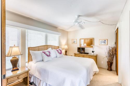 a bedroom with a white bed and a window at Manualoha 203 in Koloa